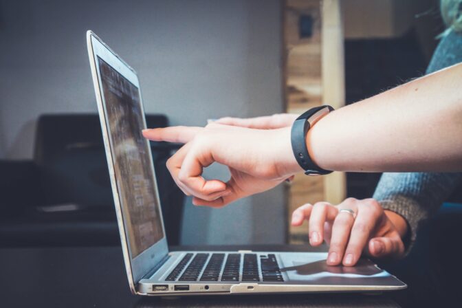 Two hands in front of a laptop
